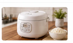 Compact rice cooker beside a bowl of cooked rice